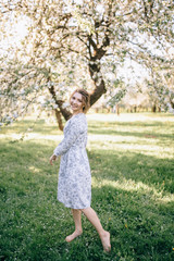 Fototapeta na wymiar beautiful young brunette woman standing near the apple tree on a warm summer day