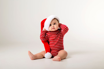 baby in a red bodysuit and Santa hat on a white background