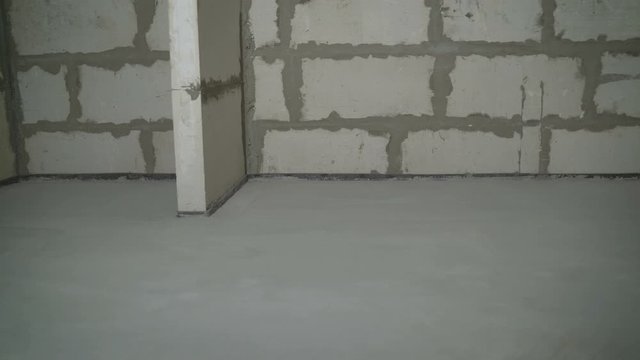 Builders leveled the floor with a mortar and a mixture. Fill screed floor repair and furnish, shallow dof. The finished result, the solution is aligned on the floor.