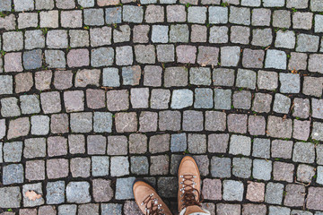 Human foots in shoes standing on the pavement