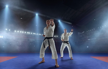 Fototapeta na wymiar Karate fighters on tatami. Fighting Championship.
