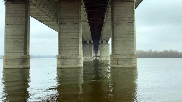 on the river bank under the basics of the bridge on a cloudy day