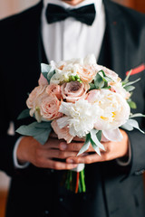 Obraz na płótnie Canvas Groom holding beautiful wedding bouquet