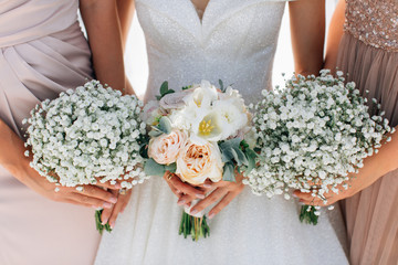 Obraz na płótnie Canvas Bride and bridesmaids holding beautiful bouquetes