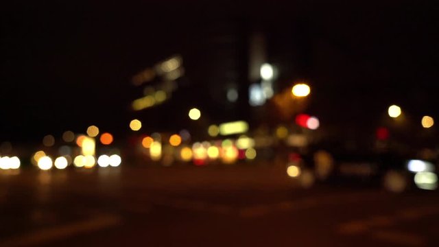 Oncoming city traffic passing through blurry shot at night