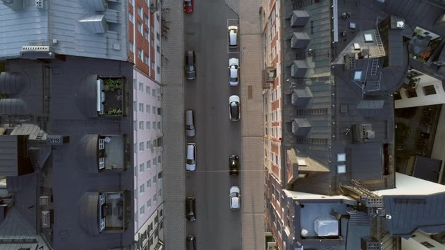 Empty street in Stockholm city, Sweden aerial top down view. Quarantined city, empty abandoned streets during corona virus outbreak. Drone shot flying over buildings, parked cars and street