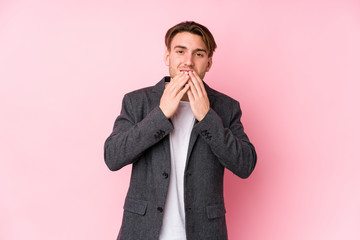 Young caucasian business man posing isolated laughing about something, covering mouth with hands.