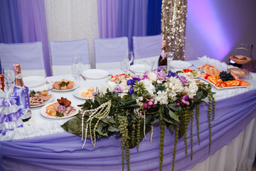 Beautiful purple newlywed wedding table decor in a restaurant.