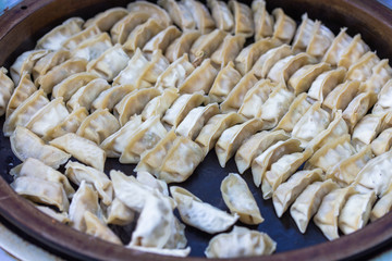 Pork and Cabbage Dumplings (Guotie or Jiaozi). Frying the dumplings from the steam. Cooking gyoza Japanese style. Asian street food. Regional Food