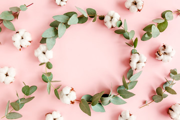 Round frame with branches eucalyptus and cotton isolated on pink background. lay flat, top view