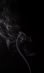 Abstract cloud of white smoke swirling on black background