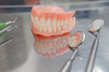 Set of dentures and dental tools. Close up Teeth and dental mirror. Diagnosis and copayment