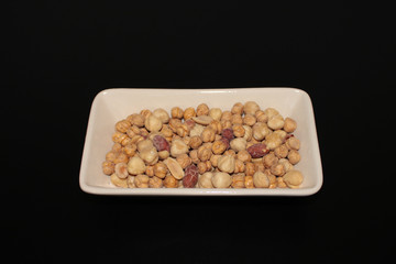 Mixed nuts in bowl, black background
