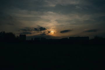 Beautiful dark sunset with clouds and sun