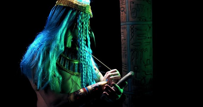 Thoth is writing on a piece of stone and looking at a column with hieroglyphics