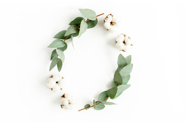 Frame made of branches, leaves eucalyptus and cotton isolated on white background. Flat lay, top...