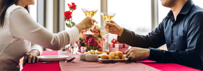Romantic young happy couple relax talking and drinking wine glasses celebrate together in the...