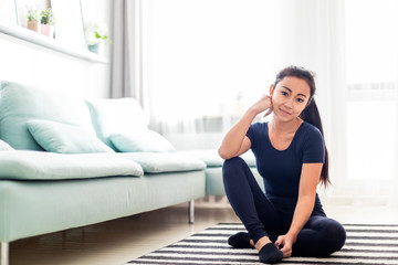 Young asian girl resting after training at home in living room
