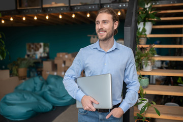 Smiling and conident man holding his computer