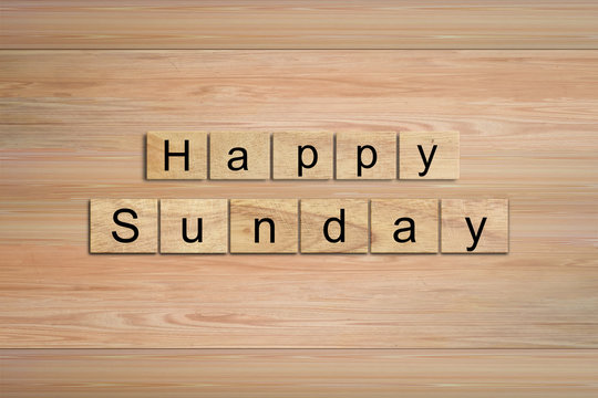 Happy Sunday word written on wood block. Message text on wooden table for backdrop design.
