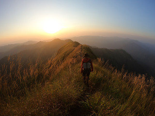 Fototapeta premium Backpacker over the mountain at sunset
