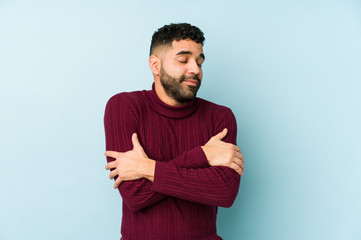 Young mixed race arabic man isolated hugs, smiling carefree and happy.