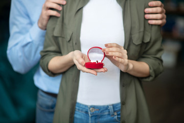 Man and a woman holding an engagement ring box