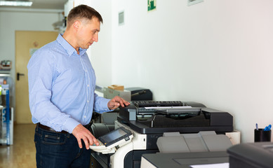 Obraz premium Confident businessman using printer in office