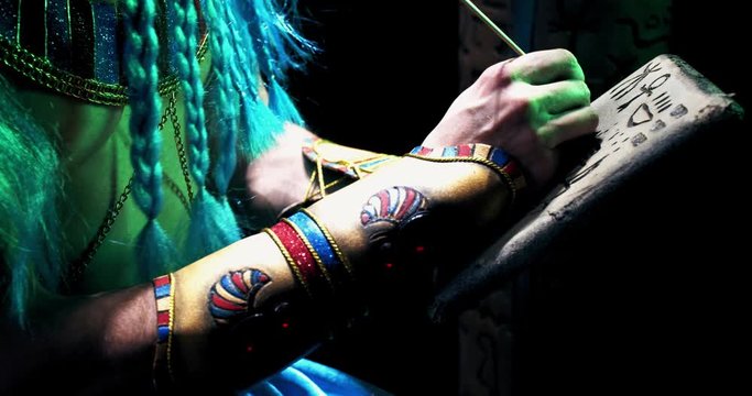 Close up of an ancient deity Thoth writing on a piece of stone, hieroglyphics