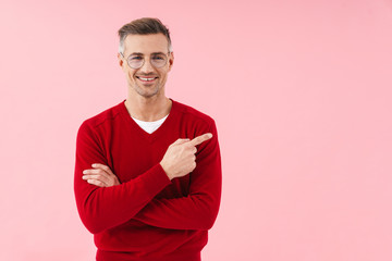 Portrait of handsome caucasian man pointing finger aside at copyspace