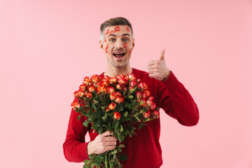 Portrait of man with kiss marks holding flowers on valentines day