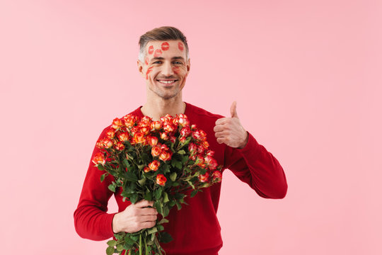 Portrait of man with kiss marks holding flowers on valentines day