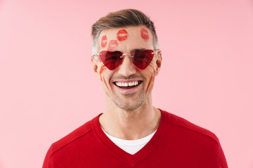 Portrait of man with kiss marks at his wearing heart-shaped sunglasses