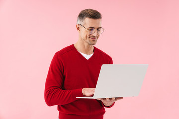 Portrait of handsome man wearing eyeglasses holding laptop computer