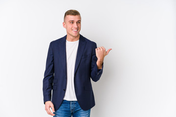 Young business caucasian man points with thumb finger away, laughing and carefree.
