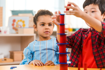 Selective focus of kids playing game during lesson in montessori school
