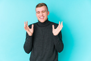 Fototapeta premium Young caucasian man on a blue background joyful laughing a lot. Happiness concept.