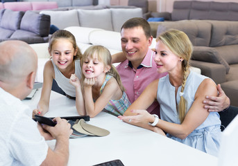 Young family of four are consulting with the seller