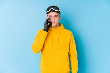 Young skier man with fingers on lips keeping a secret.