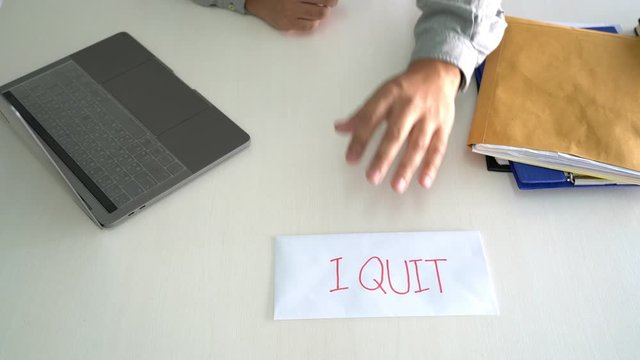 4k video of Business man signing his resignation in office write I Quit on letter before sending to his boss, concept of decision to resign job.