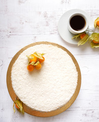 Homemade delicious sweet cake with physalis and fruits, orange on white background with cup of coffee americano. Organic dessert sugarless. Healthy eating.
