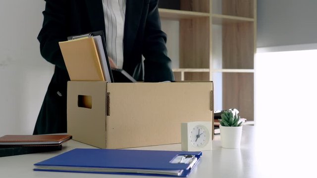 4k video of Businessmen packing up all for personal belongings and files into a brown cardboard box resignation from the company, job placement and vacancies concept.