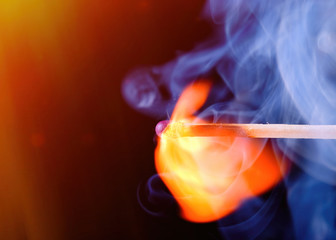 Burning match with blue smoke