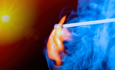 Burning match with blue smoke