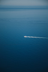 Obraz premium Coast of Majorca. in the middle a small, white yacht on the calm sea. summer scenery.