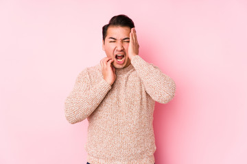 Young curvy man posing in a pink background isolated whining and crying disconsolately.