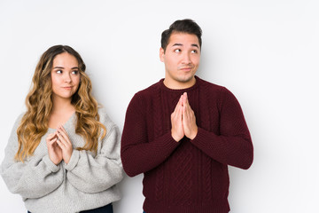 Young couple posing in a white background making up plan in mind, setting up an idea.
