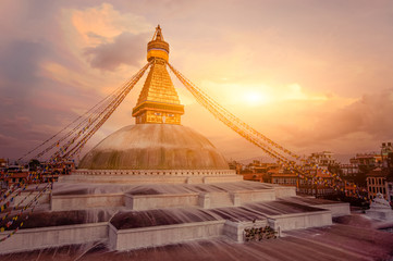 Buddhist Shrine Boudhanath Stupa with pray flags over sunset sky. Nepal, Kathmandu