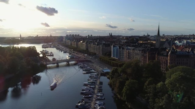 Aerial view of Stockholm city canal in &Ouml;stermalm district at sunset. Drone shot flying over river and tourist boat, cityscape skyline, Strandv&auml;gen, Capital city of Sweden