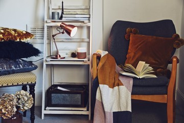 Cozy hygge interior with rocking chair, blanket and book